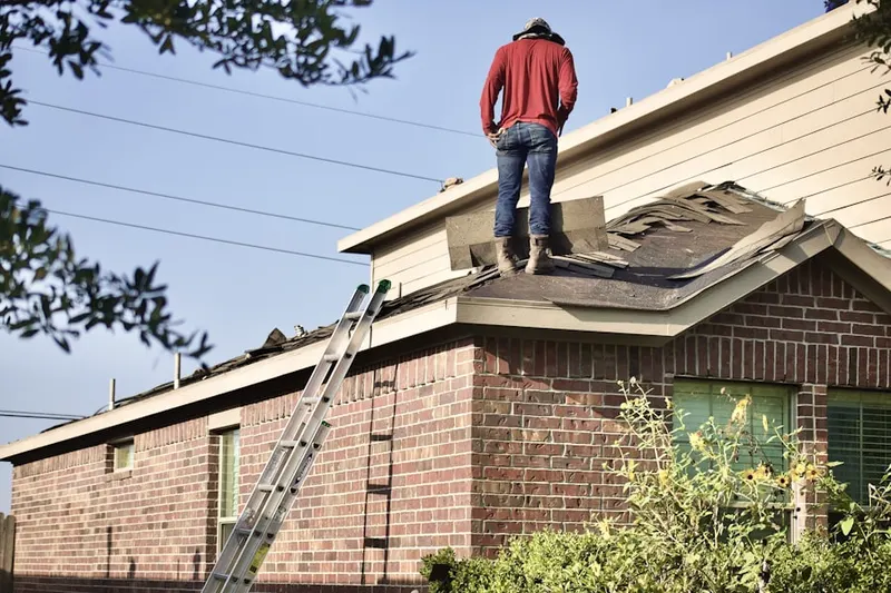 Professional roofer working on a residential roof in Womack Courts